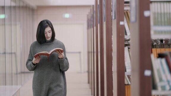 亚洲女学生在图书馆挑选书籍
