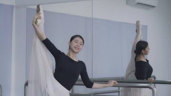 年轻的亚洲芭蕾舞演员在演播室表演舞蹈指导绕着自己旋转在上台前进行训练