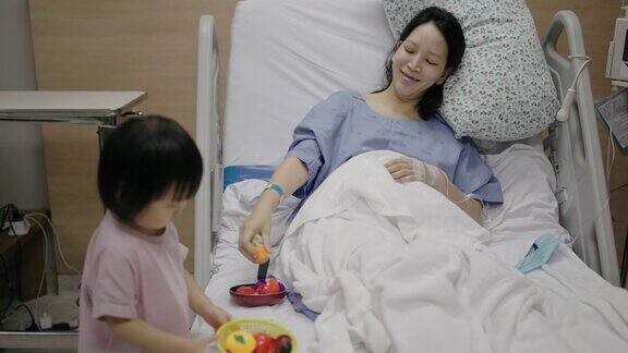 生病的母亲和女儿在医院里玩耍