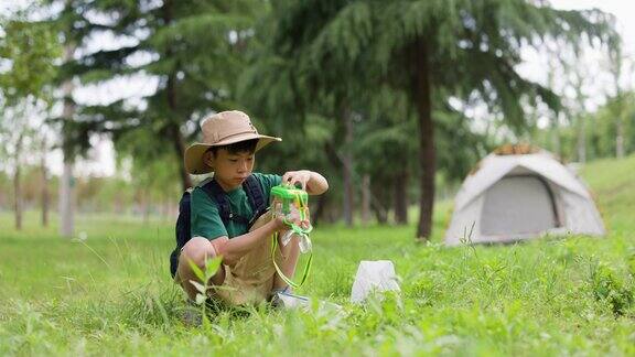一个亚洲男孩正在户外捉昆虫