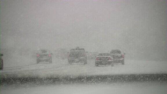 暴风雪冬季交通汽车在滑溜溜的路上行驶下雪雪花