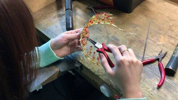 近距离拍摄亚洲华裔女学生在大学工作台制作手工珠宝