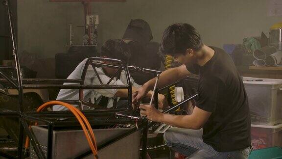 广角团队的年轻亚洲机械工程师工作在工作室车间技术与创新理念