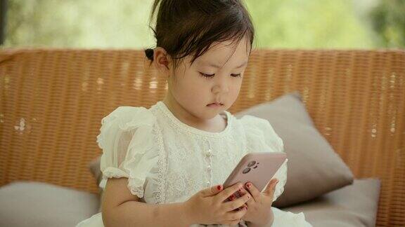 那个亚洲小女孩正在玩她的手机