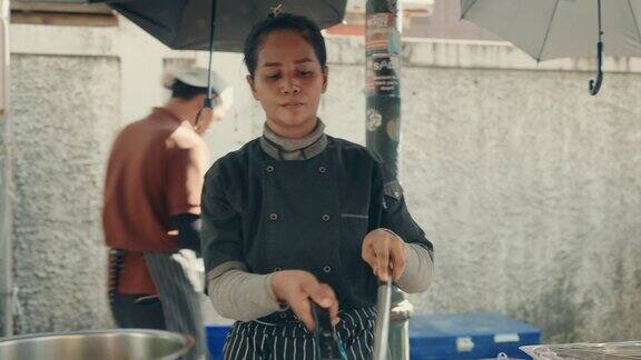 正宗的泰国食物准备由女厨师-烹饪泰式炒粉在曼谷街头市场