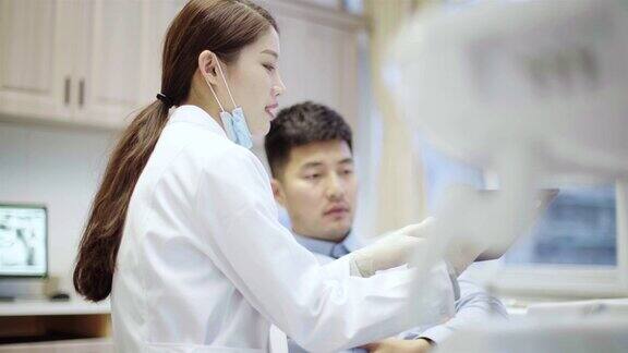 牙医给病人看牙齿x光片