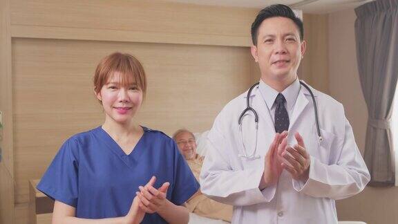 亚洲医生和护士微笑鼓掌鼓励病人的肖像医疗队站在医院康复室的病床前