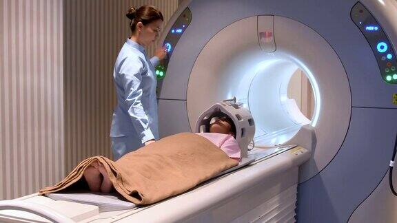 小女孩躺下准备做核磁共振扫描