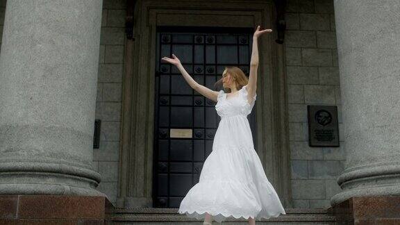 身穿白色礼服的年轻舞者在剧院的楼梯上慢动作跳舞芭蕾舞女演员在户外跳舞4k120fpsProresHQ