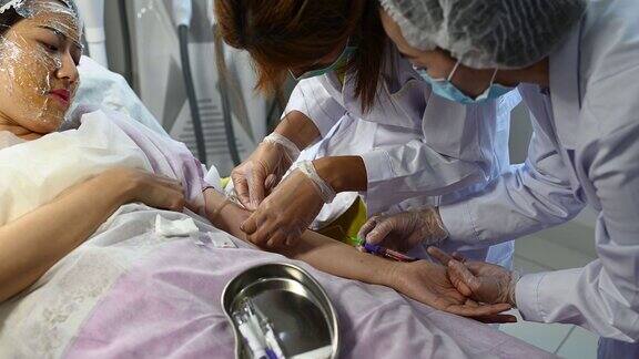 亚洲华人女医生护士从年轻女子身上取血