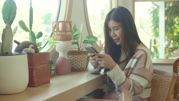 可爱的女人在咖啡馆放松时使用手机