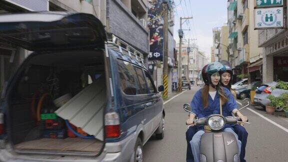 两名年轻的亚洲女性在台湾街头骑摩托车