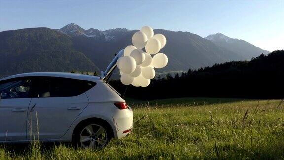 白色的气球正从山上的白色汽车里飞出来