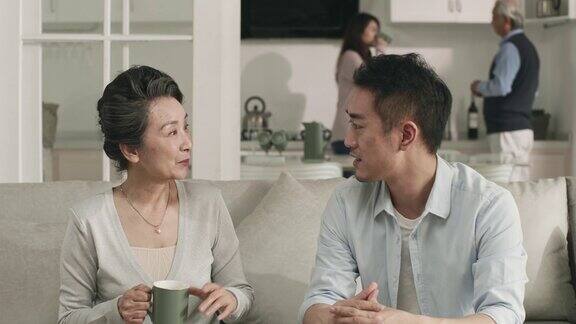 亚洲成年儿子和年长母亲在家聊天