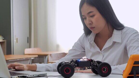 一名少女在教室里用笔记本电脑编写机器人程序创新、教育、技术、科学和人的理念教育的主题4.0行业网络物理系统概念机器人和工程师女性在干