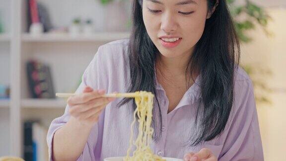 微笑的亚洲女人在镜头前吃面条美食博主在享受美食直播