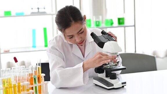 4K从事医学研究的女科学家在显微镜下观察