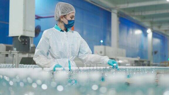 亚洲华人水厂生产线女工携带个人防护用品日常检查水瓶工作