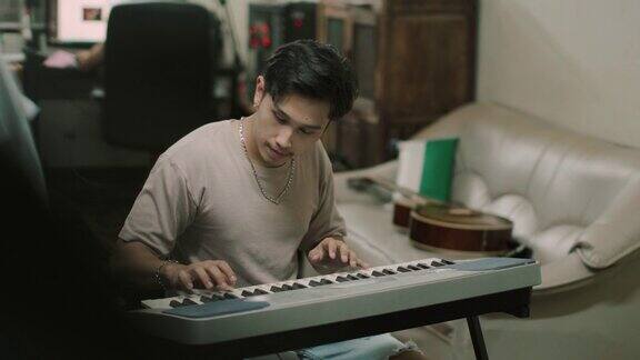 一个年轻人在家里练习钢琴