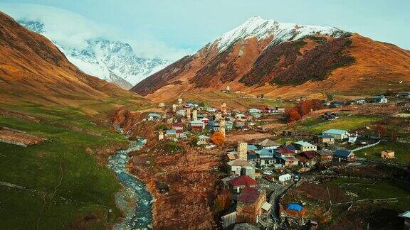 无人机拍摄的格鲁吉亚斯瓦涅季地区Ushguli村和Svan塔中世纪石塔民居以高加索山脉为背景秋日自然景观