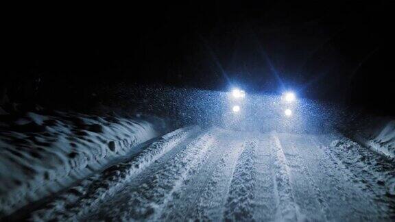 在下雪的夜晚汽车行驶在下雪的道路上