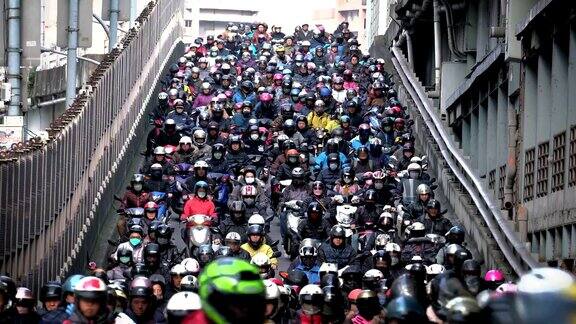 成群的人骑着摩托车穿过城市的桥上交通拥挤