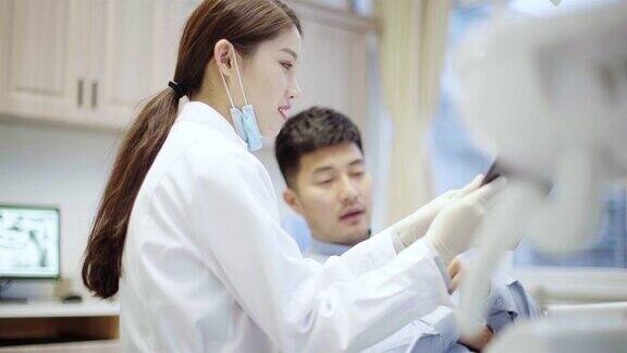 牙医给病人看牙齿x光片