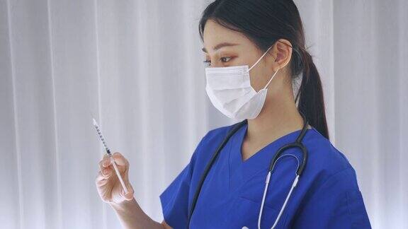 近距离的女性亚洲医生持有疫苗注射针准备接种疫苗年轻的医学实验室技术员在工作