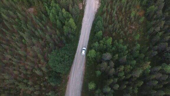 无人机拍摄的森林中蜿蜒的乡村道路汽车在森林中行驶的鸟瞰图