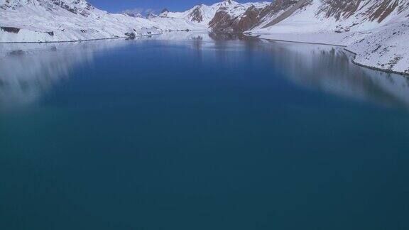 空中宽幅倾斜向上看蓝色高山原始蒂利科湖在尼泊尔被雪喜马拉雅山脉包围直达世界上最高的高山湖泊