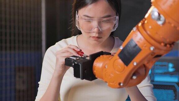 一个未来主义的假肢机器人手臂由一个亚洲十几岁的女孩开发工程师在一个研究实验室晚上工作到很晚手臂移动手指技术工作到很晚科学领导、教育主题工业4.0创新STEM领域的女性