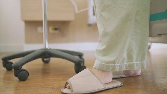 无法辨认的女性病人的脚下床静脉滴注站