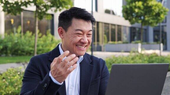 快乐微笑积极的韩国商人律师自由职业者男性投资者雇主企业家微笑成功的在线项目在股票市场上赢钱使用笔记本电脑wifi户外互联网