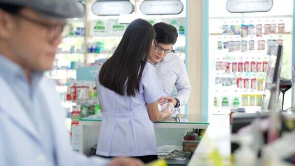 4K亚洲女药剂师在药店向男性顾客讲解药物和补品