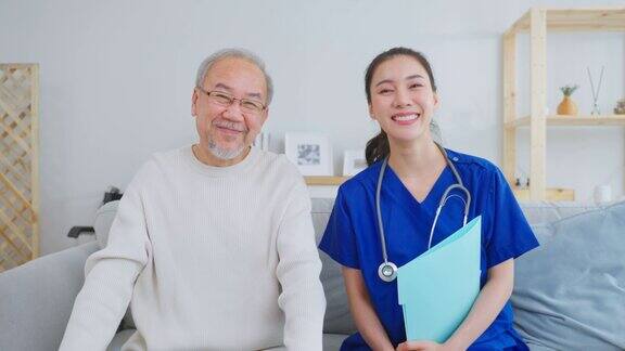 亚洲护理护士坐在沙发上照顾老人的肖像有吸引力的专业护理员妇女支持年长的成熟的老爷爷在养老院照顾和微笑看着相机