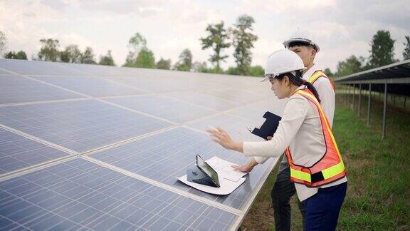 太阳能电池板电站电气工程师检查建筑外的太阳能电池场