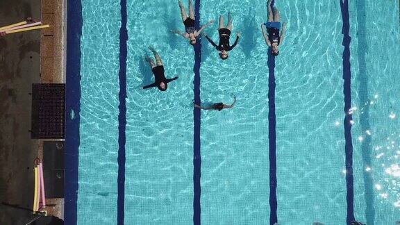 无人机的角度正上方游泳池教练指导她的学生游泳技能