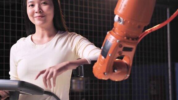 一个未来主义的假肢机器人手臂由一个亚洲少女微笑开发工程师在一个研究实验室晚上工作到很晚手臂移动手指技术工作到很晚科学领导、教育主题工业4.0创新STEM领域的女性