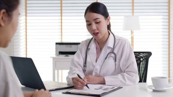 迷人的美丽年轻的亚洲医生女穿着白袍听诊器在肩上诊断与病人谈话提供帮助咨询治疗或解释处方在办公室诊所