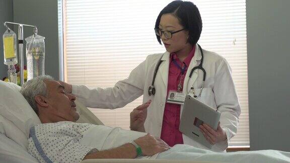 女医生在医院病床上对一位老年病人说话