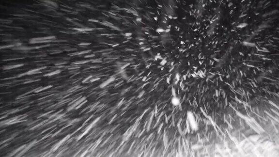 夜晚驾驶通过暴风雪的冬季风暴挡风玻璃Pov雪花在前灯