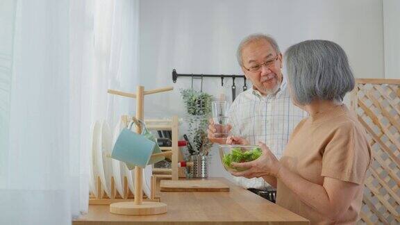 亚洲老年夫妇在家里的厨房里一起做沙拉幸福的家庭有魅力的年长成熟的夫妻享受退休生活在家里制作健康的食品健康幸福