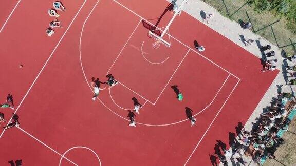 男孩们在户外公共篮球场上打篮球的俯视图