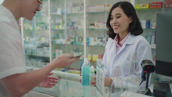 亚洲男子顾客在药店扫描支付二维码购买药品