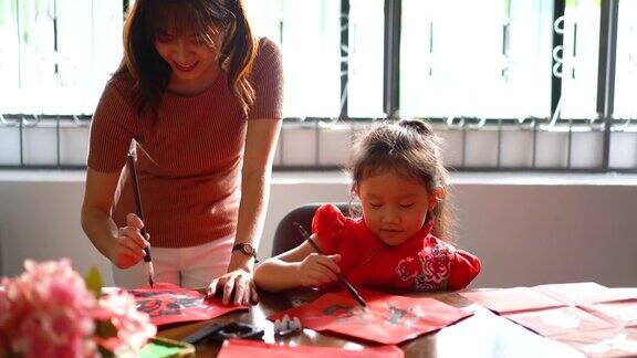 亚洲华人家庭在红纸上书写中国书法