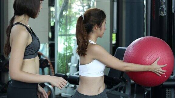女士在健身房里用健身球做侧向伸展运动