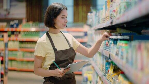 一名超市女工作人员正在记录货物的相关数据