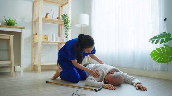 在家里帮助老年男性避免摔倒的亚洲护理员老年病人在做物理治疗后发生意外然后在客厅被漂亮的治疗师护士救了出来