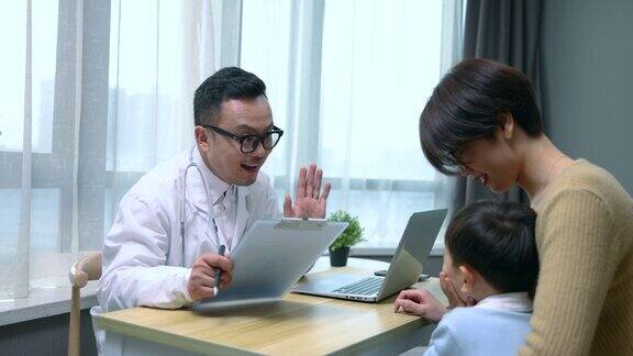 医生正在检查小男孩并与母亲交谈
