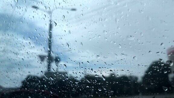 雨滴落在汽车的透明玻璃上